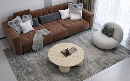 Modern living room with a brown sectional sofa, round coffee table, and decorative pillows.