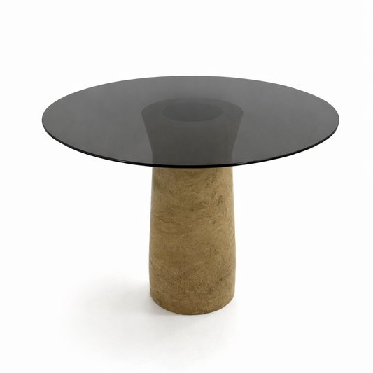 Modern dining table with a dark glass top and marble base on a white background