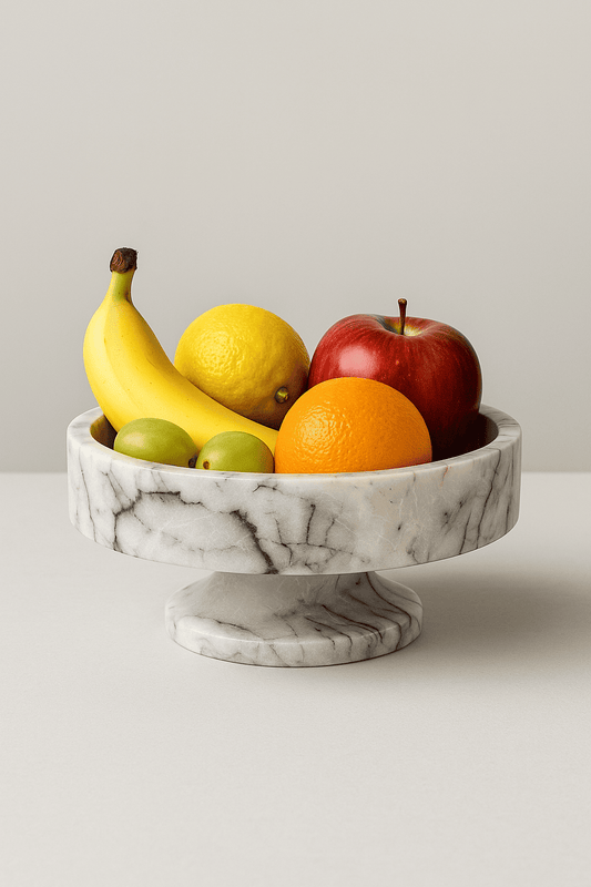 Marble Fruit bowl with bananas, apples, oranges, and lemons on a marble stand against a plain background