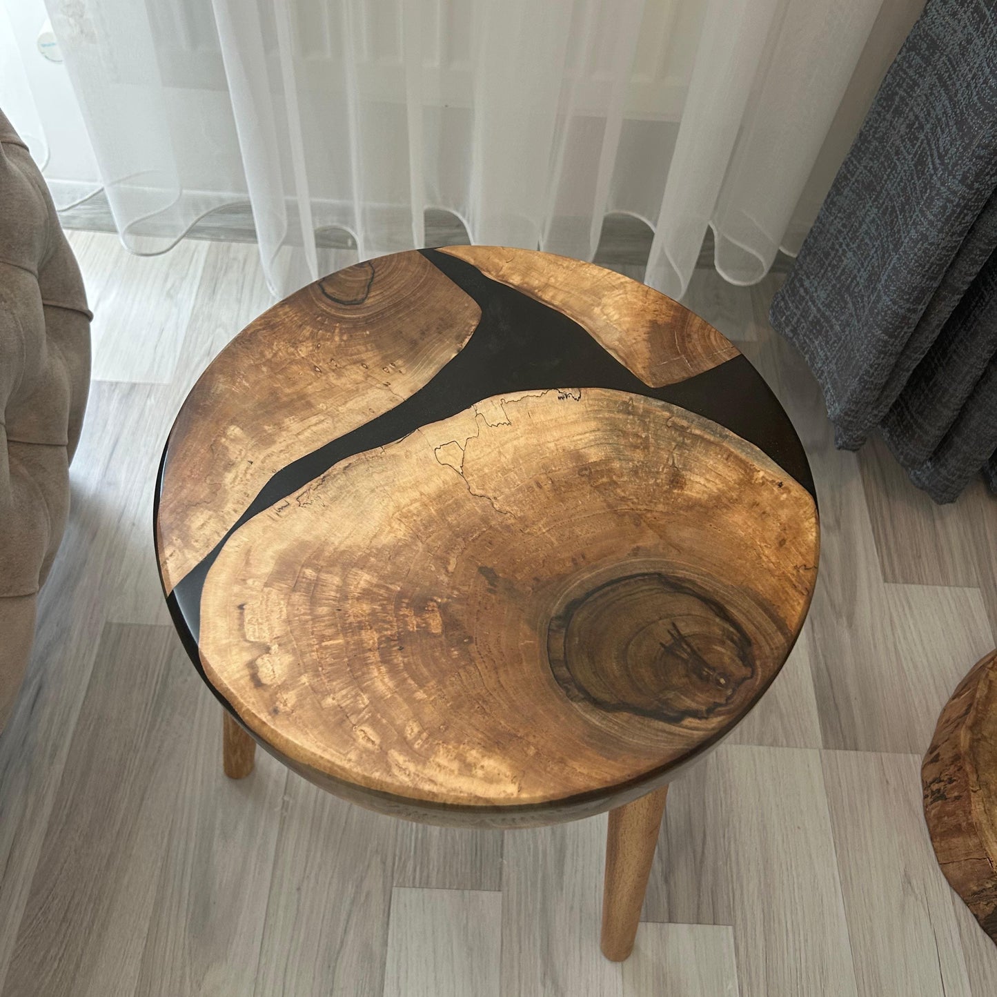 Round wooden side table with a unique design in a room setting