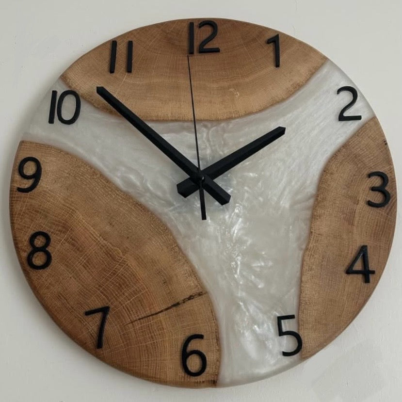 Wooden wall clock with a white center and black numbers on a light background