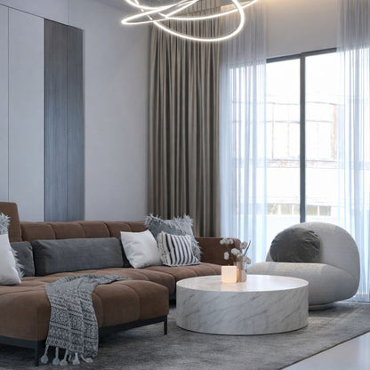 Modern living room with a brown sectional sofa, marble coffee table, and large windows.