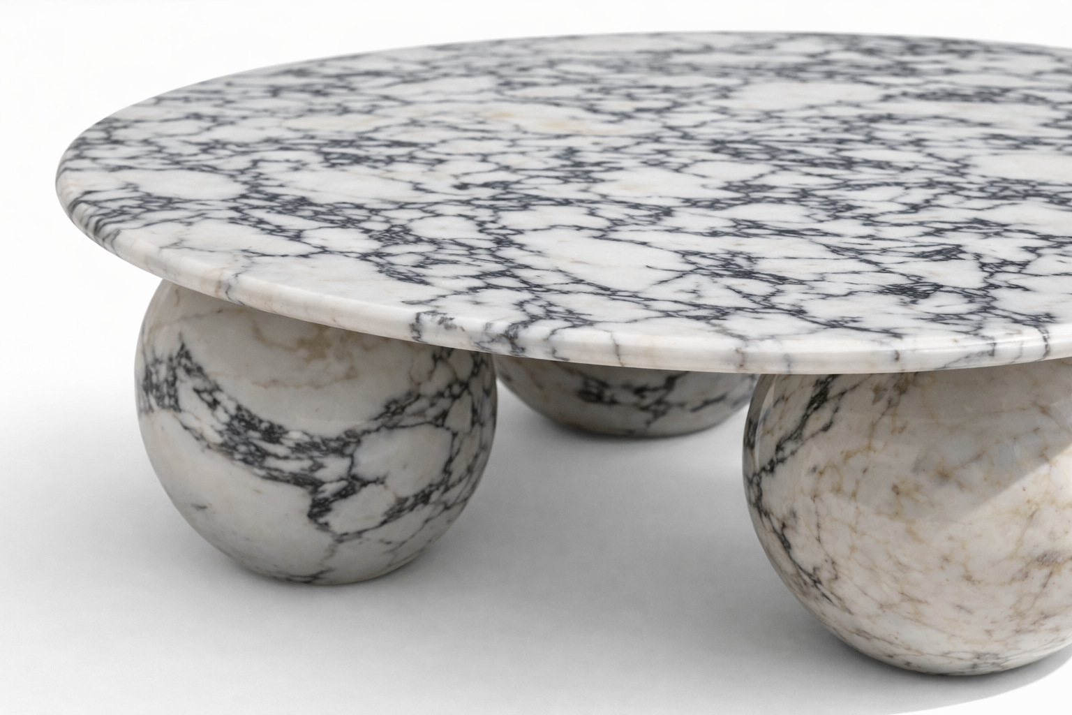 Marble coffee table with spherical bases on a white background