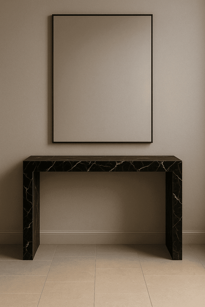 Black marble console table against a beige wall with a large mirror.