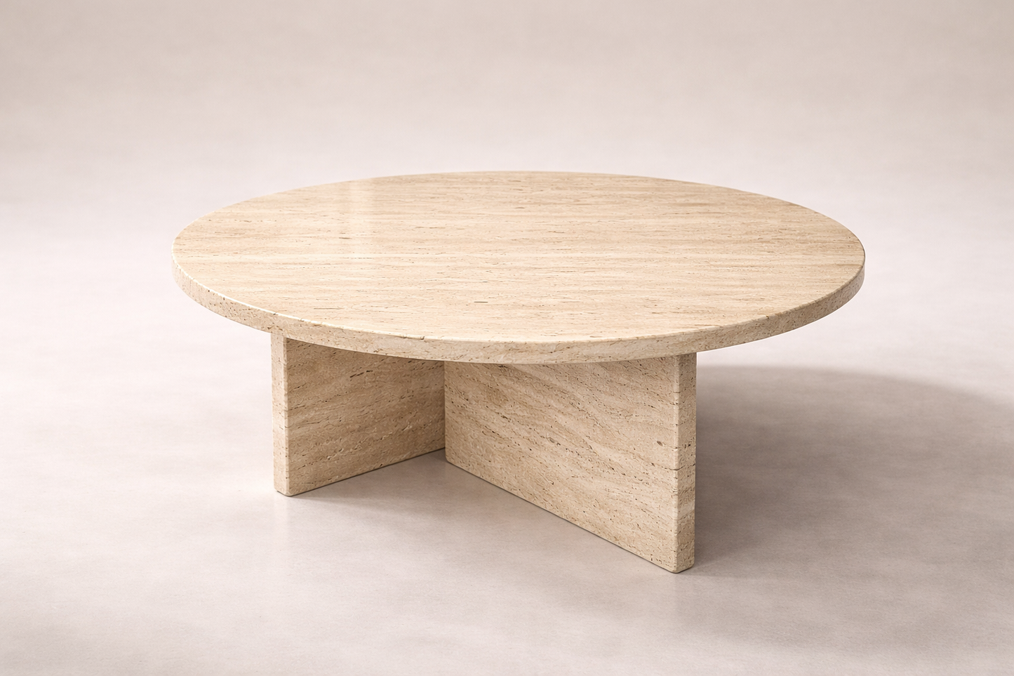 Round travertine marble table on a plain background