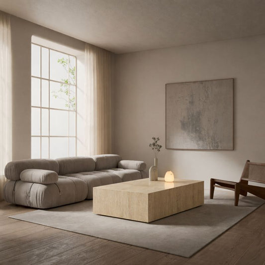Modern living room with a beige sofa, marble travertine coffee table, and abstract painting.