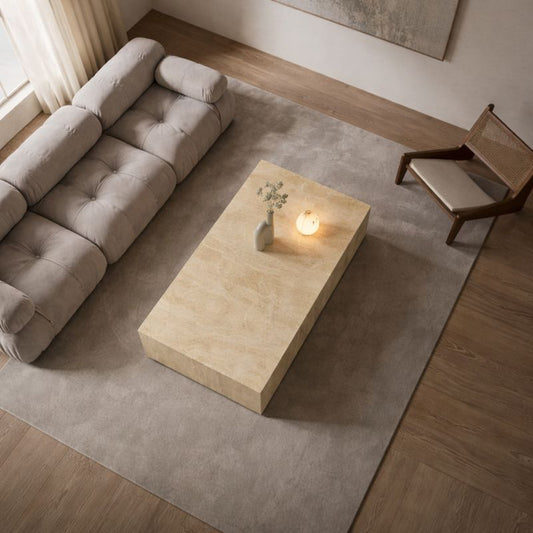 Modern living room with a beige sofa, marble travertine coffee table, and abstract painting.