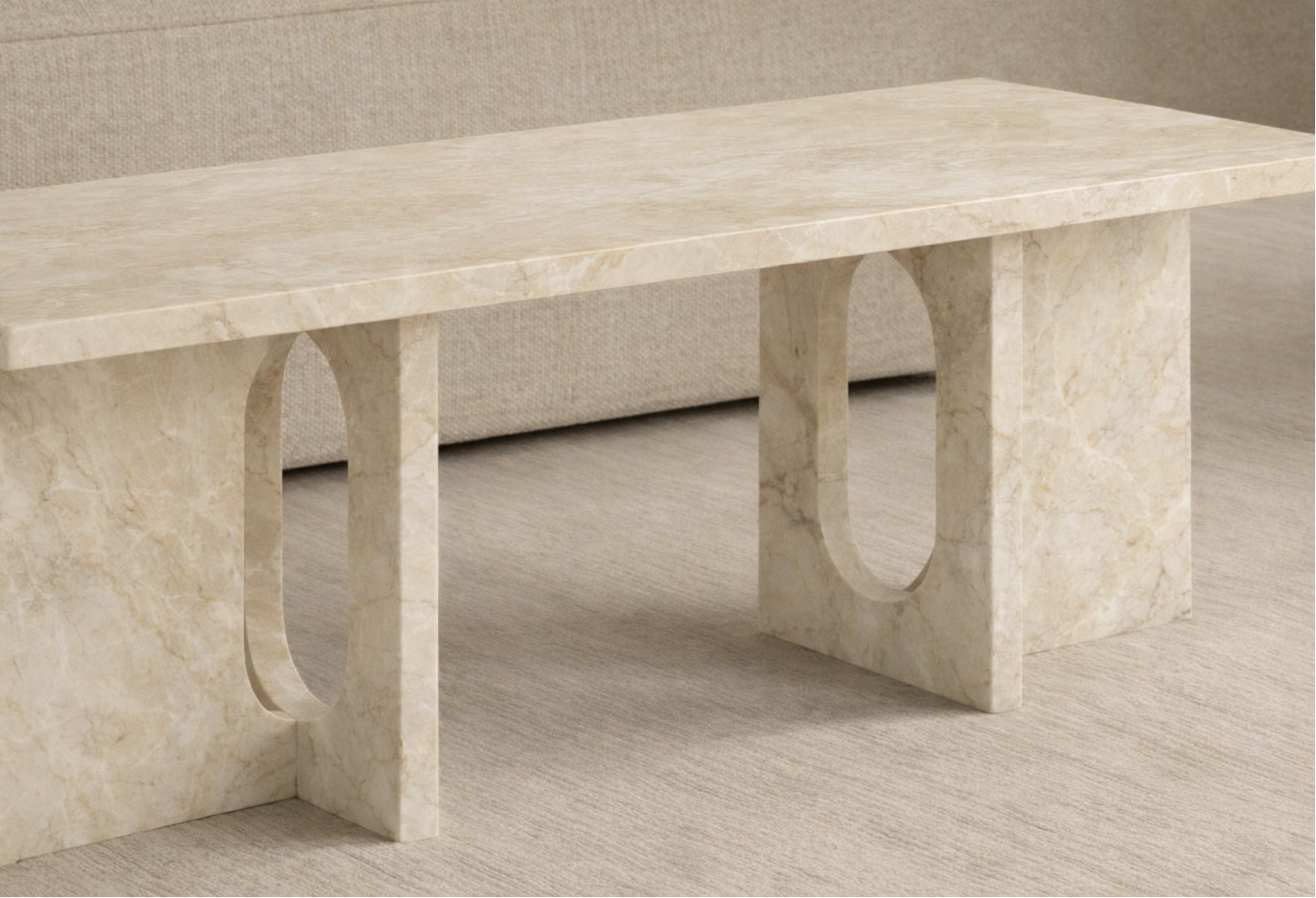 Beige marble table with unique curved legs on a neutral background