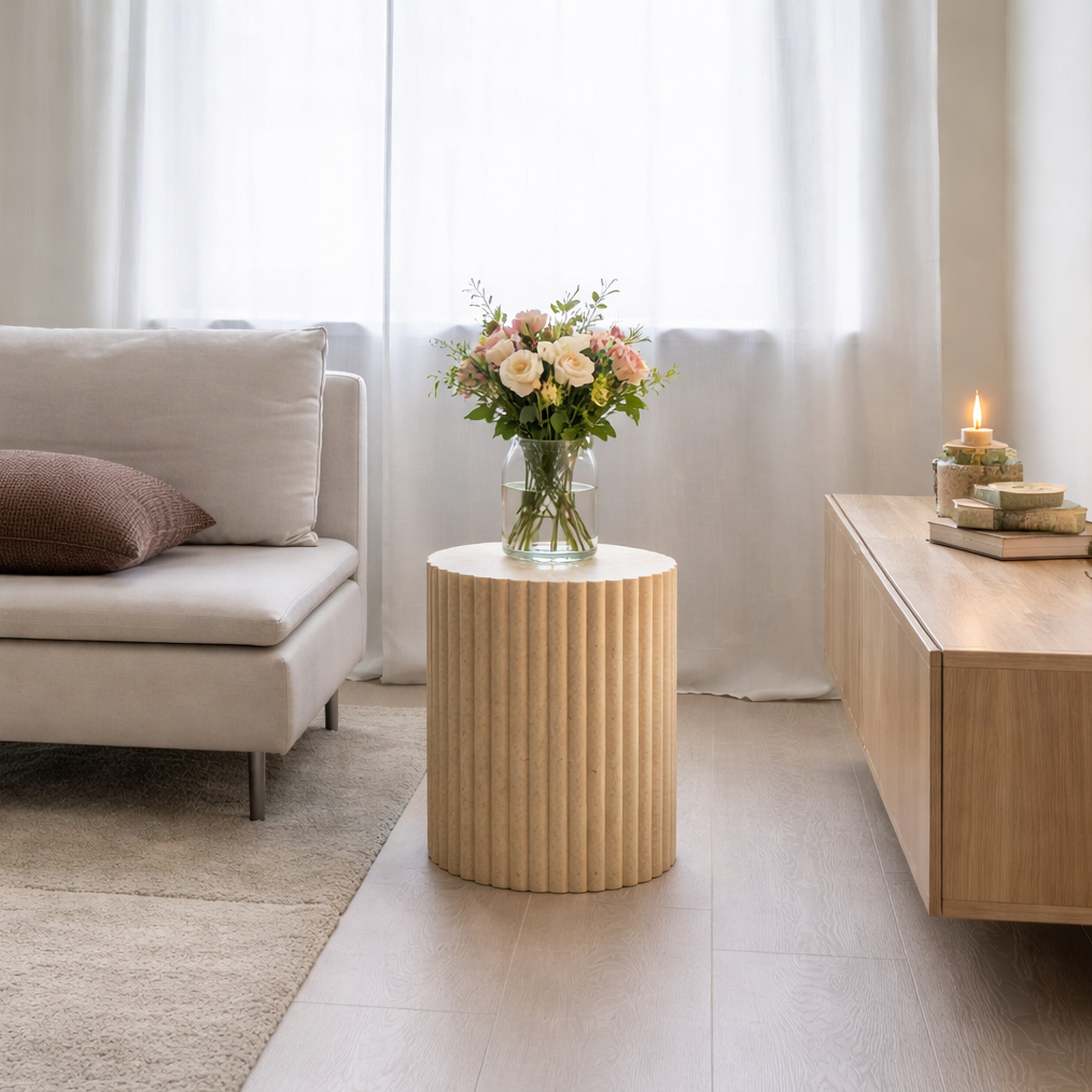 Modern living room with a beige sofa, marble side table, and decorative items.