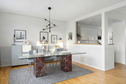 Modern living room with a marble dining table and light fixtures.