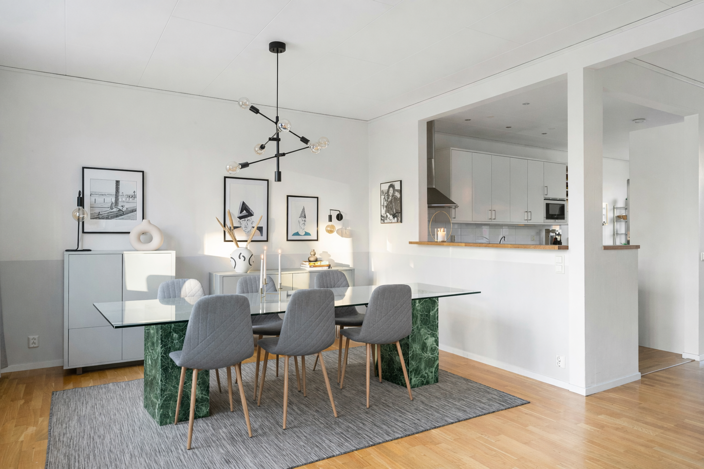 Modern dining area with marble table and chairs in a well-lit room.