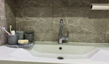 Sustainable 5-piece gray marble bathroom set with gold or silver pump. Includes dispenser, dish, tumblers, and tray. Handcrafted by Aurora Marble artisans.