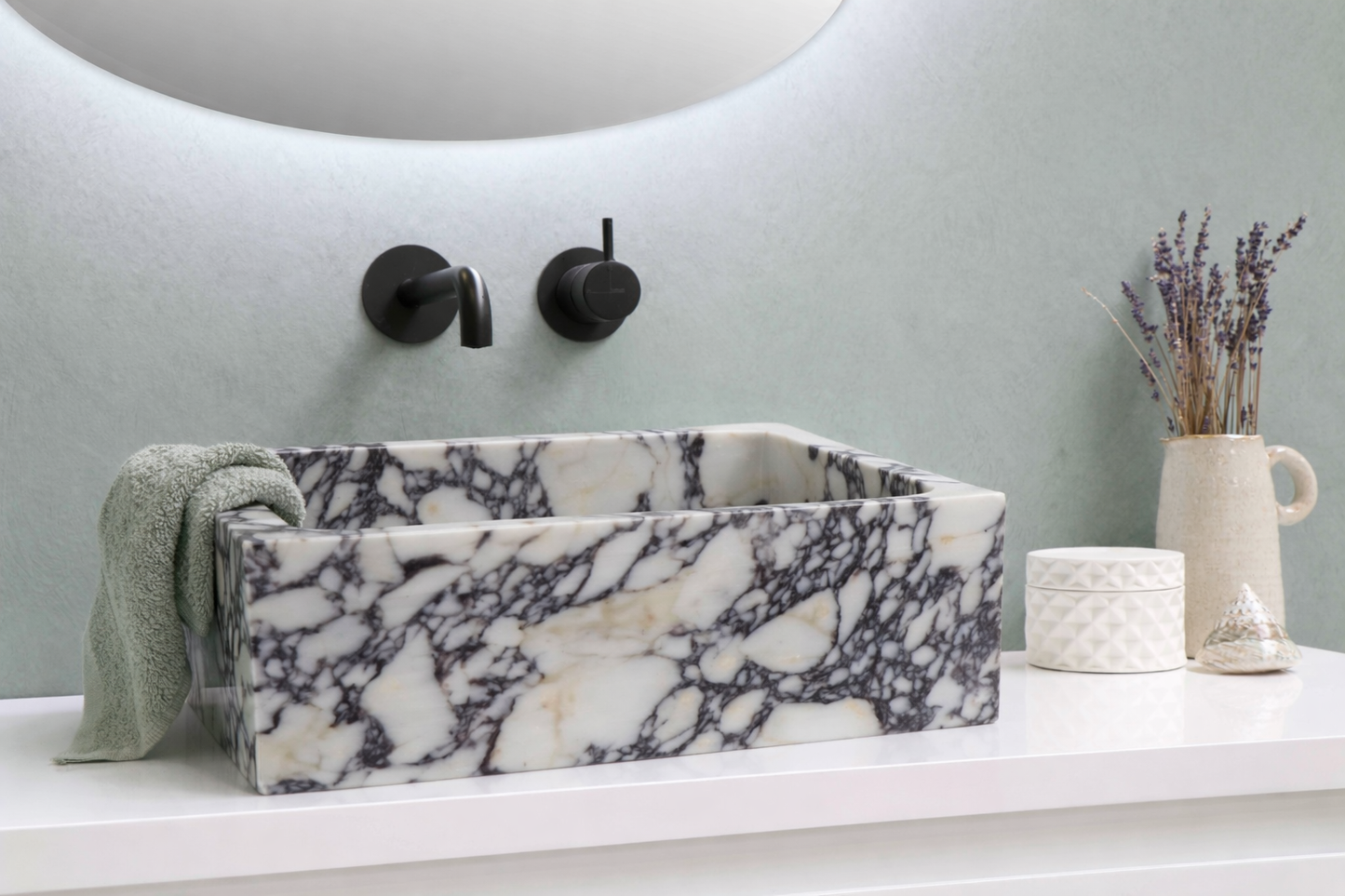 Marblesink with black fixtures in a bathroom setting.