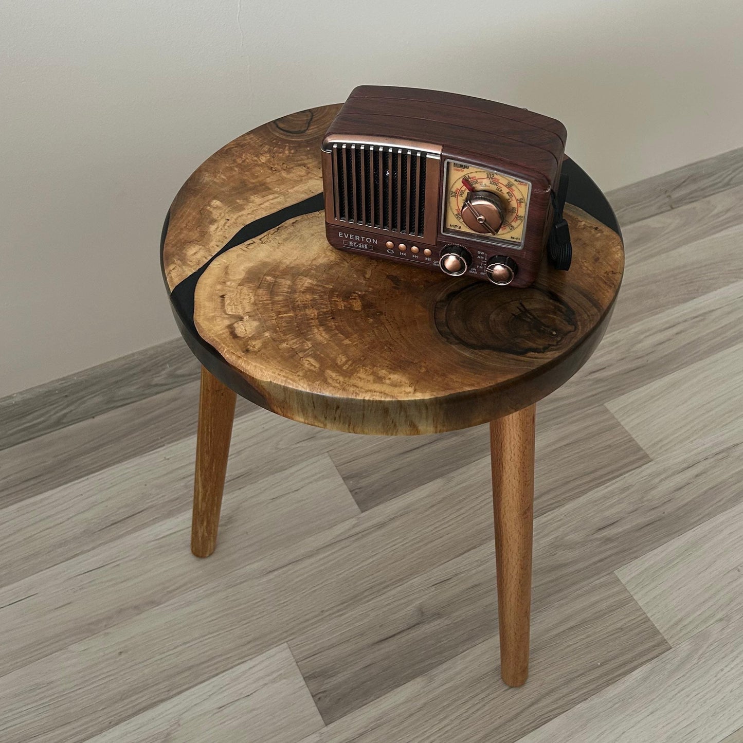 Vintage radio on a round wooden table with a plain background